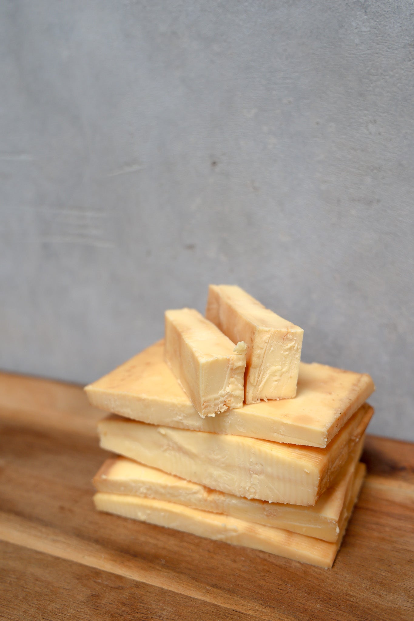 Packaged Smoked Havarti Offcuts from Eltham Cheese Bar on a wooden surface with a concrete wall background