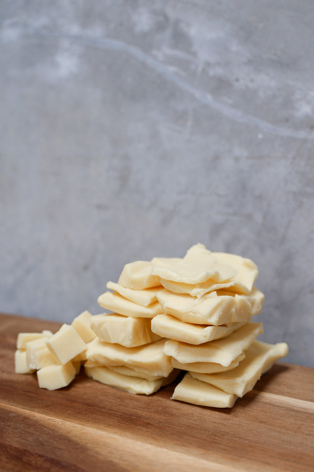 Stack of Mozzarella Offcuts from Eltham Cheese Bar on a wooden surface with a gray concrete background