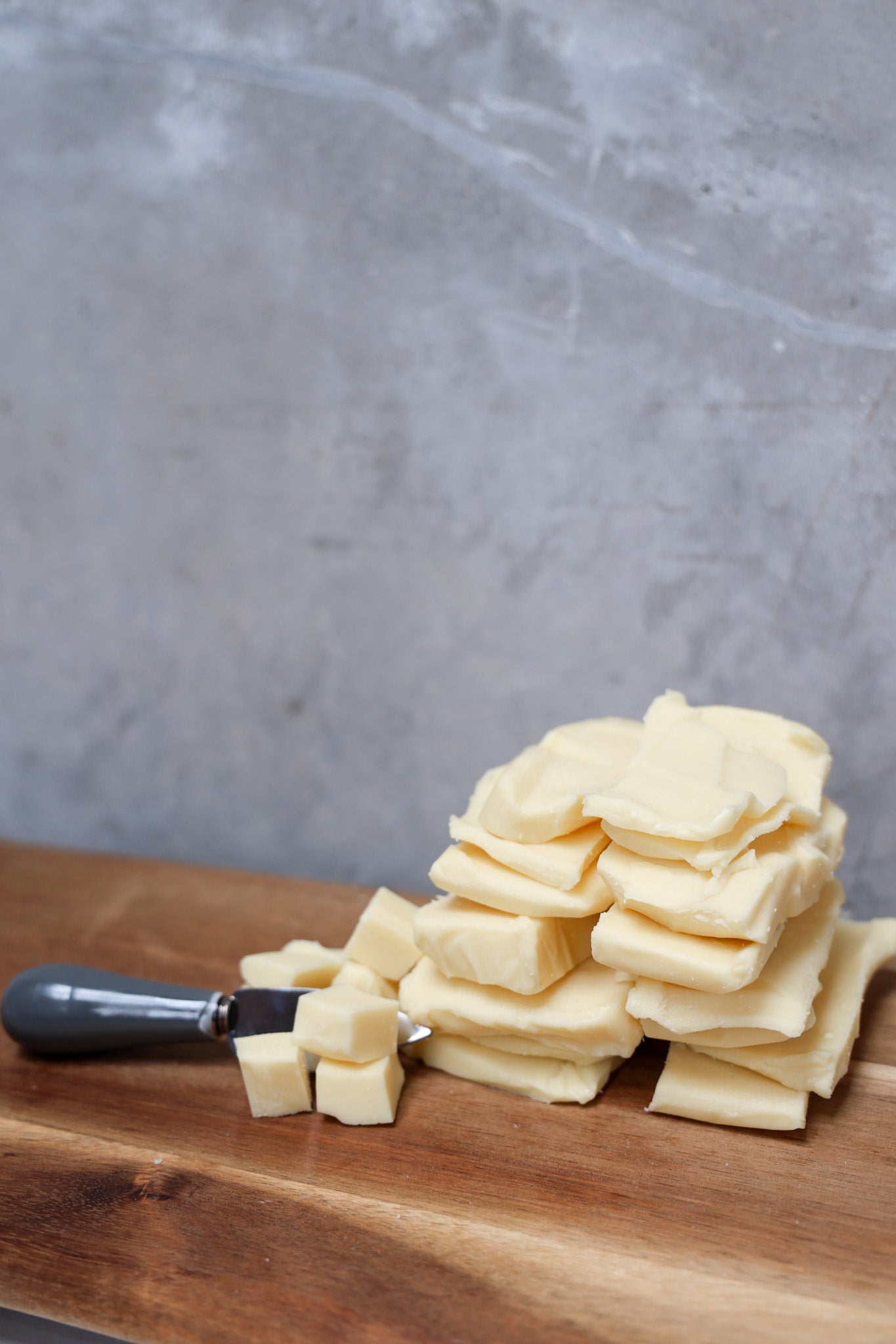 Stack of Mozzarella Offcuts from Eltham Cheese Bar on a wooden surface with a gray concrete background