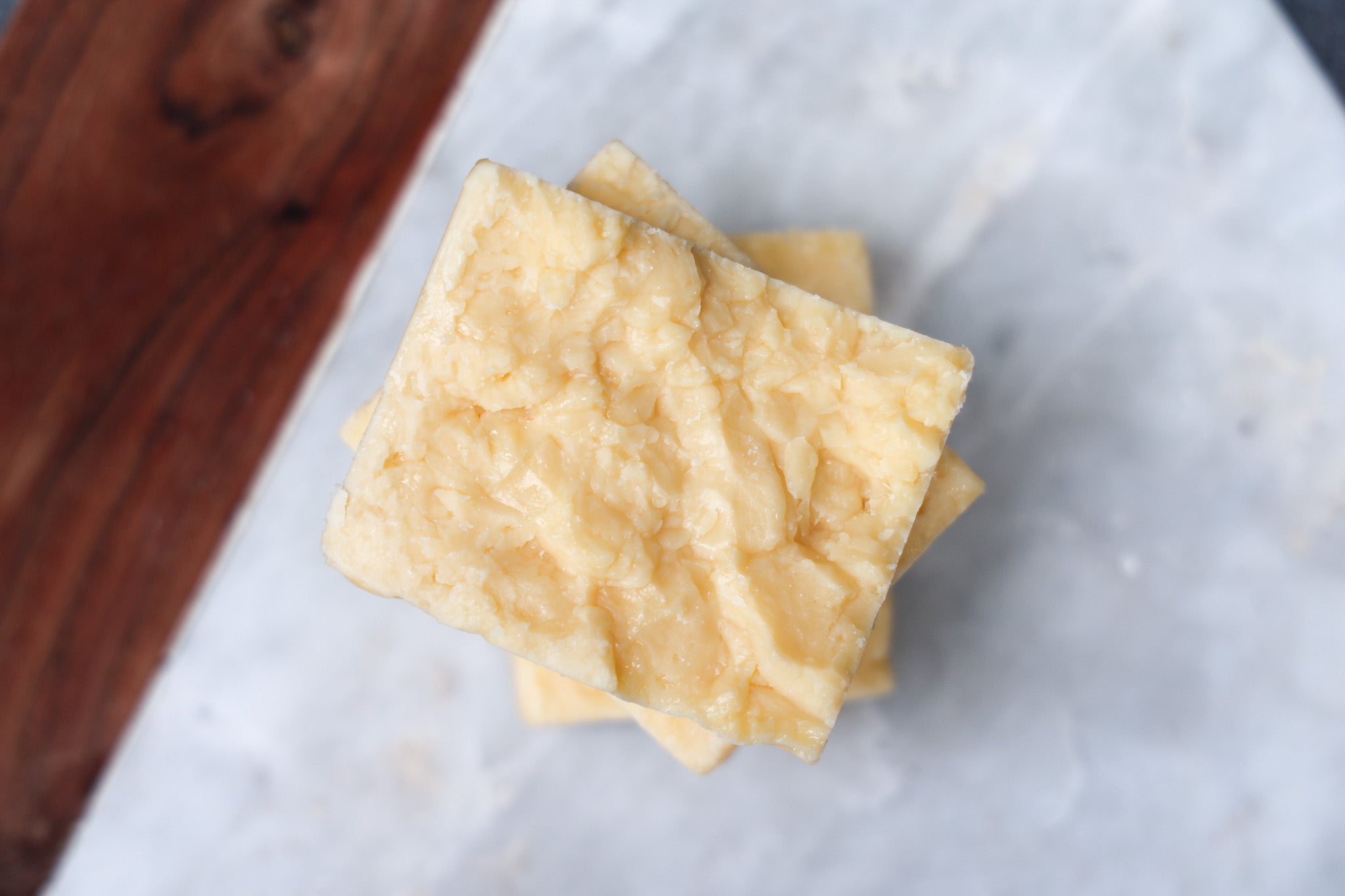 Stack of parmesan cheese from Eltham Cheese Bar on a marble chopping baord